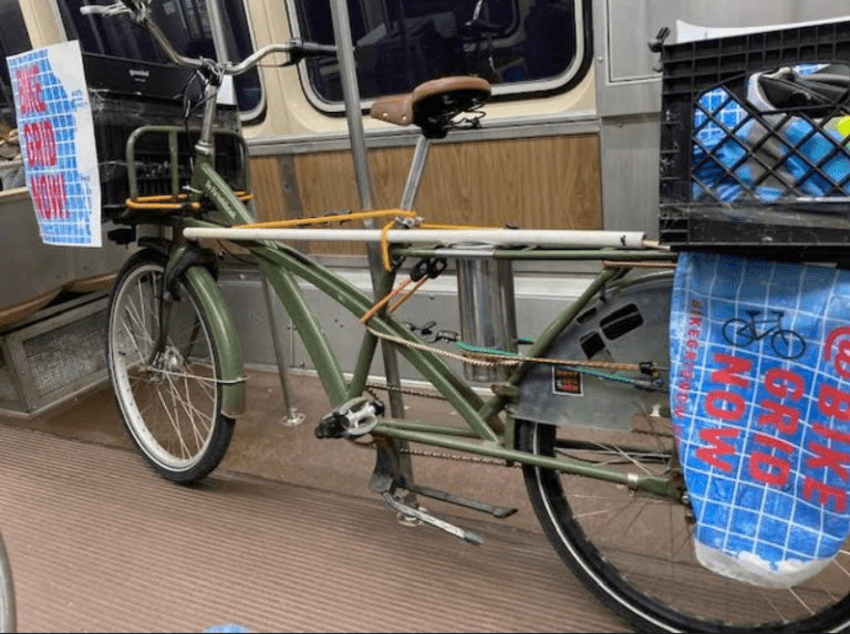 A bike on the CTA with a Bike Grid Now poster on its back side.